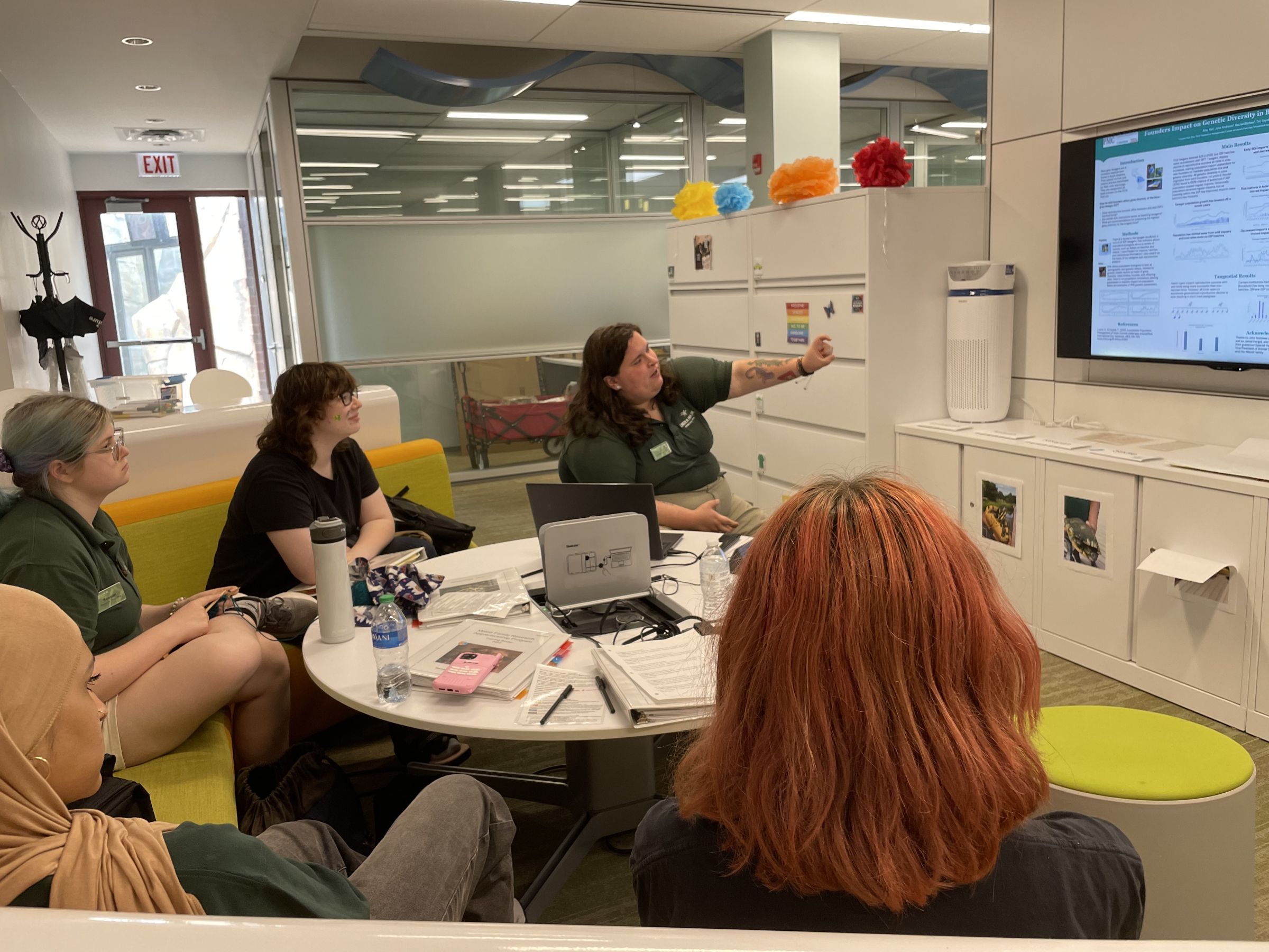 CJ shows teen program participants how to create a scientific research poster.