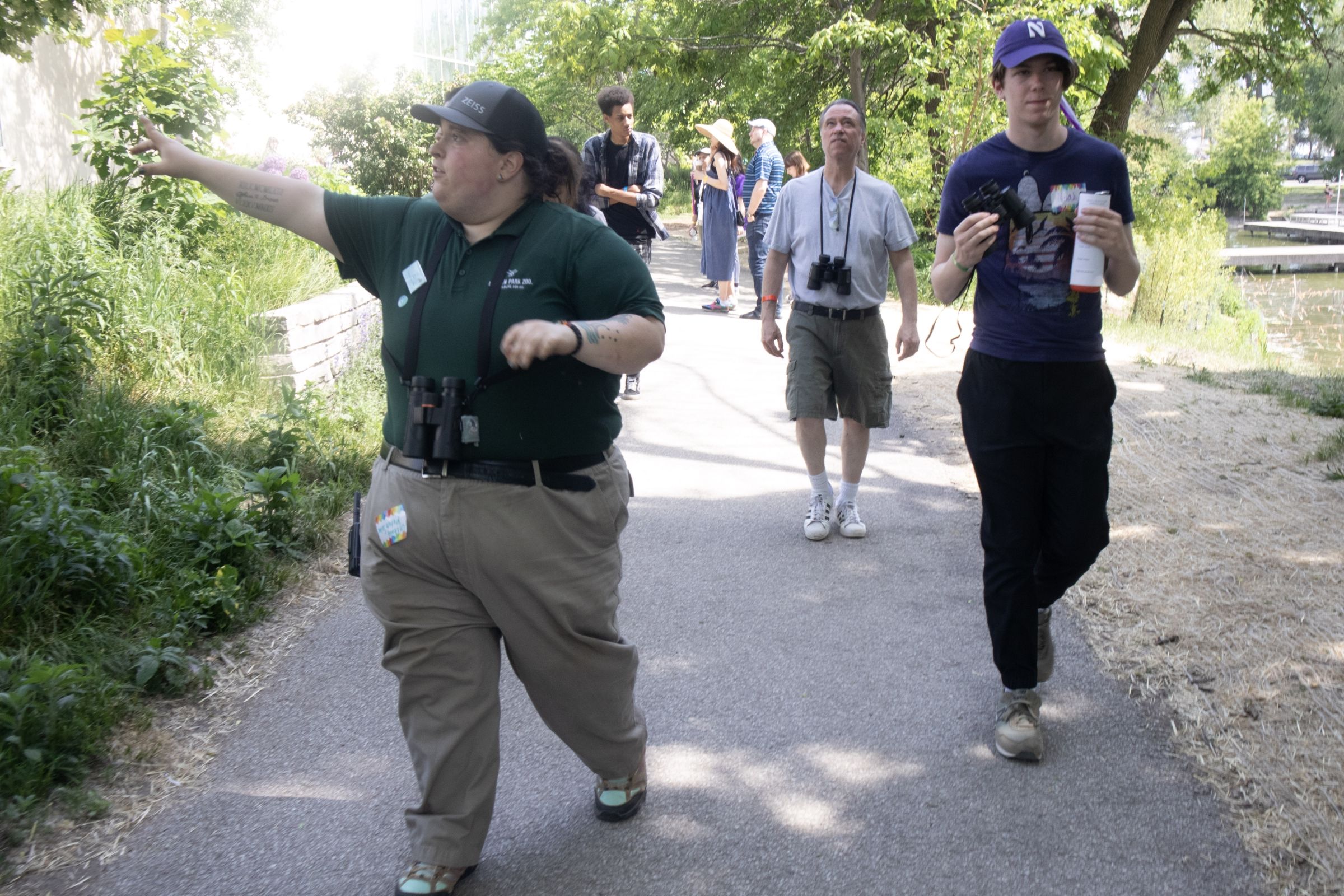 CJ pointing to something off camera and guiding a group of people on a bird outing.