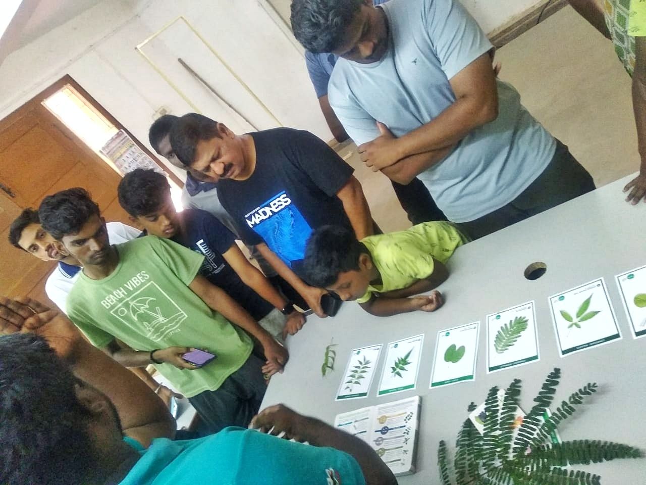 Srinivasan explaining about leaf identification techniques using our lead type flashcards during a tree walk