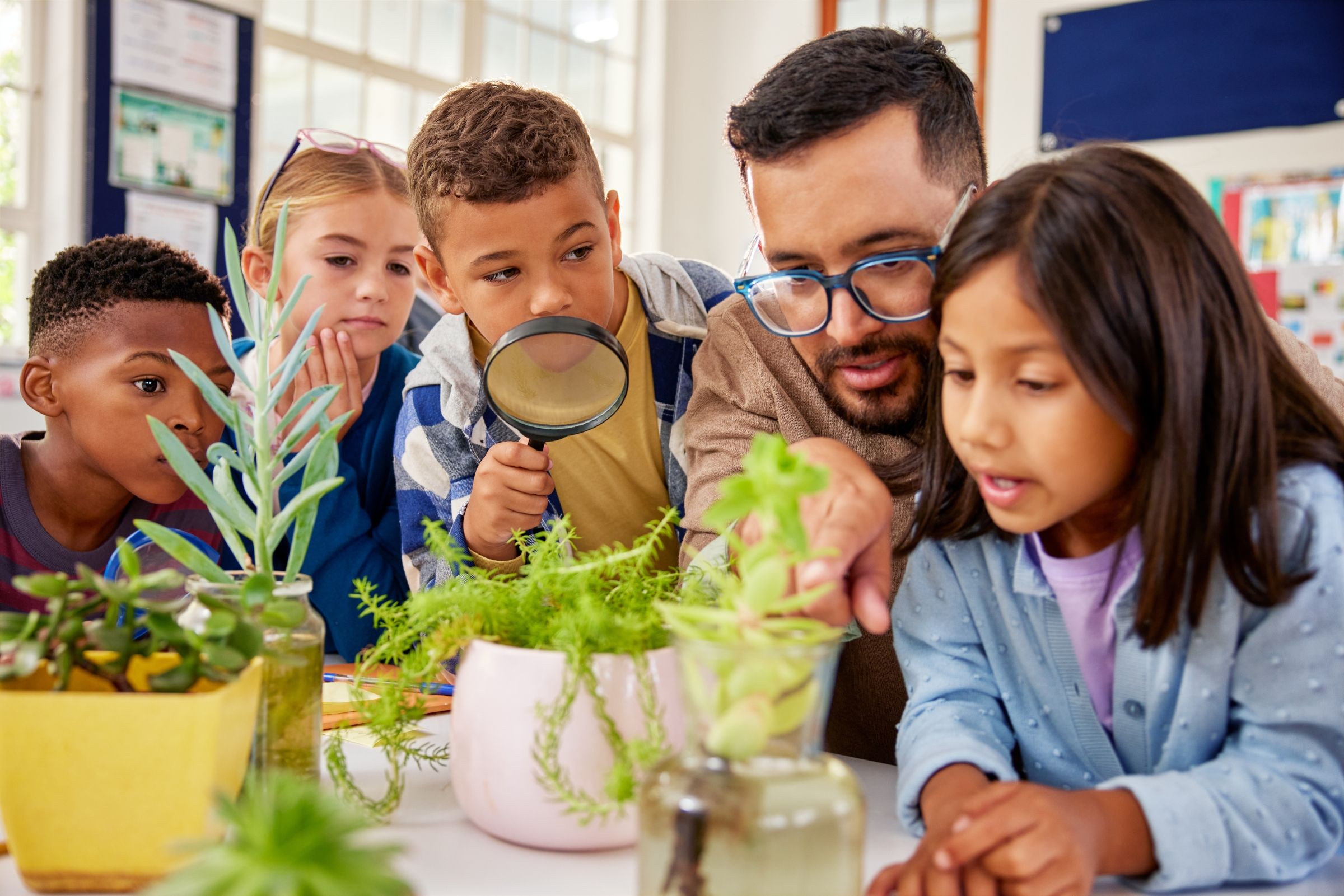 teacher and young students studying plants
