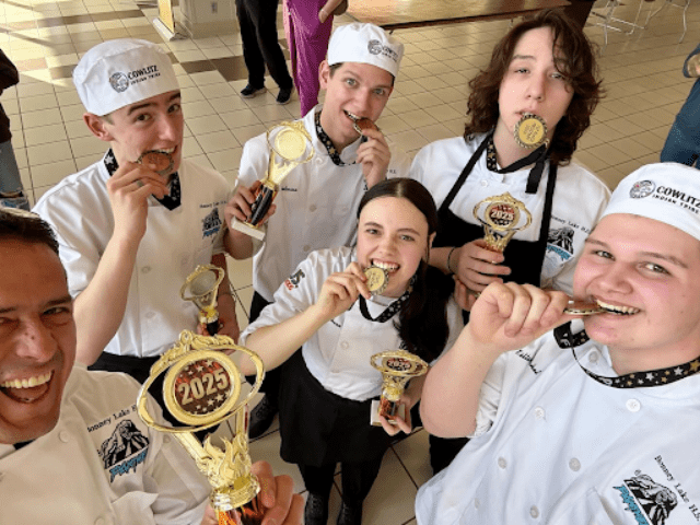 Group of high school students celebrate winning a cooking competition