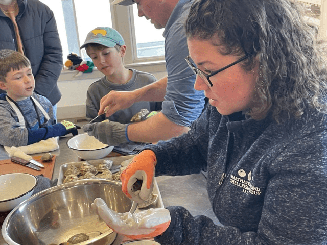 A woman shucks an oyster