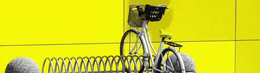 bike on bike rack against bright yellow wall