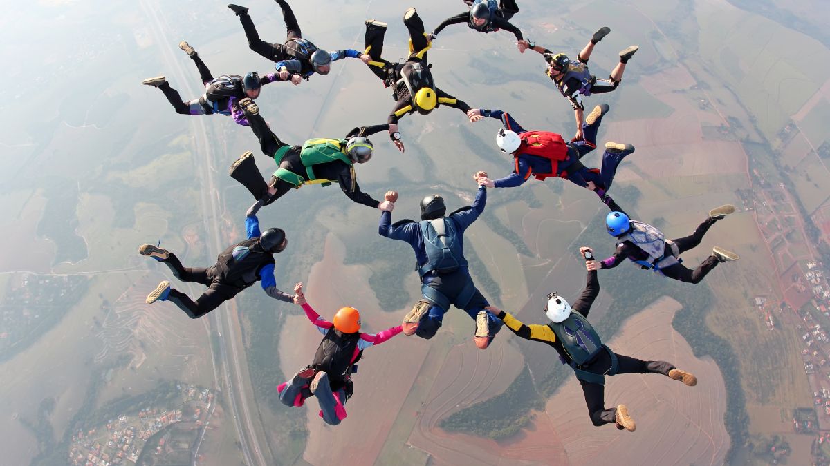 group of people forming a net while skydiving 