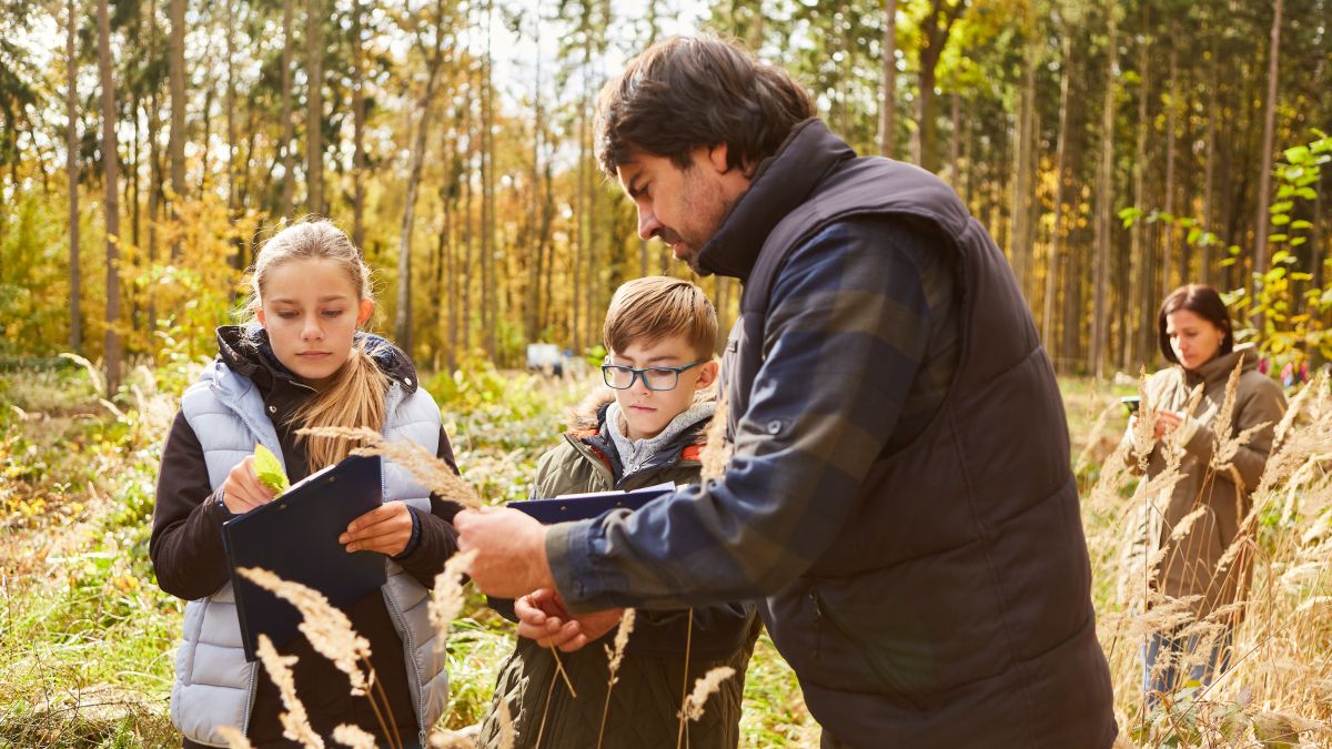 Forester and two children in tree science lessons