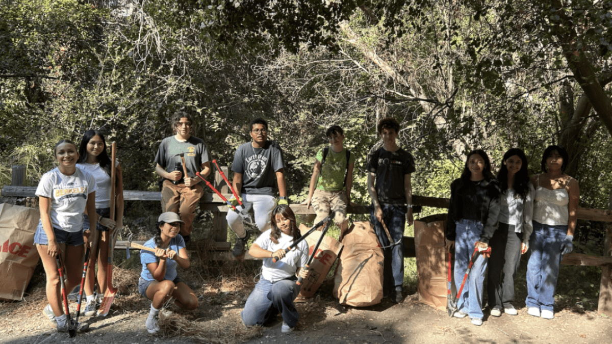 Students pose for a group photo in a forest
