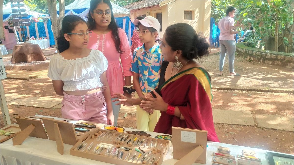 A woman talking with children outside with a table of nature objects