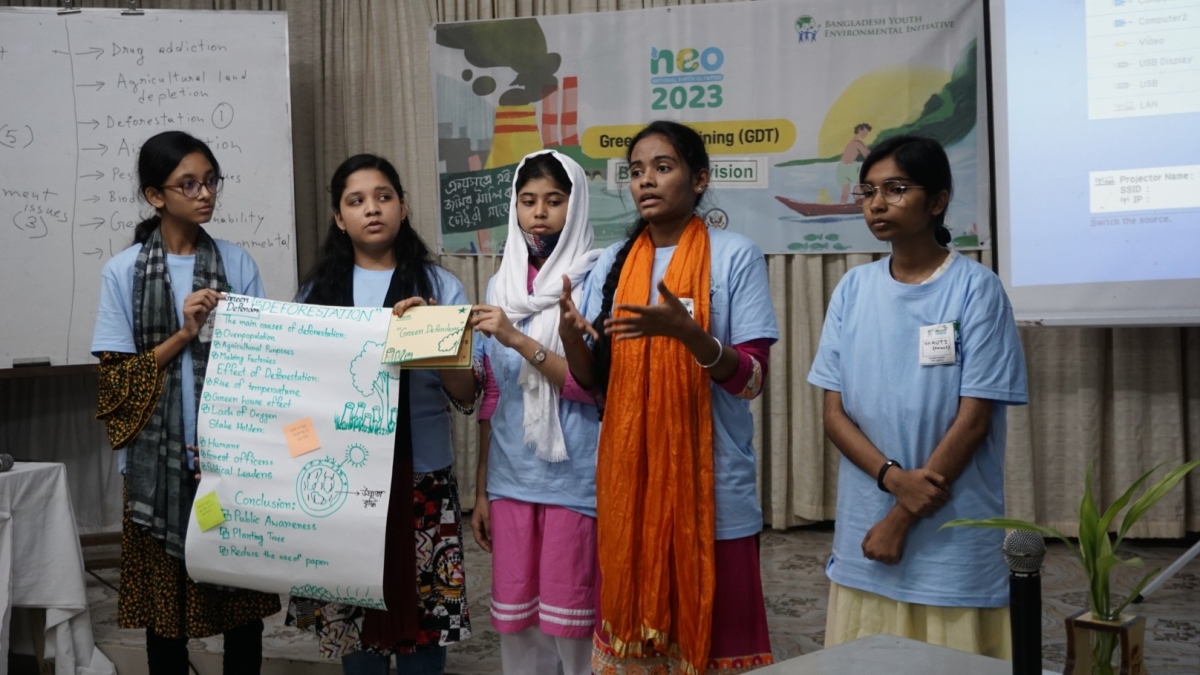 students holding up a poster and making a presentation