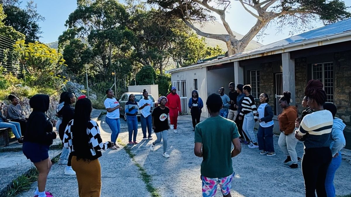 A group of students in a circle outside.