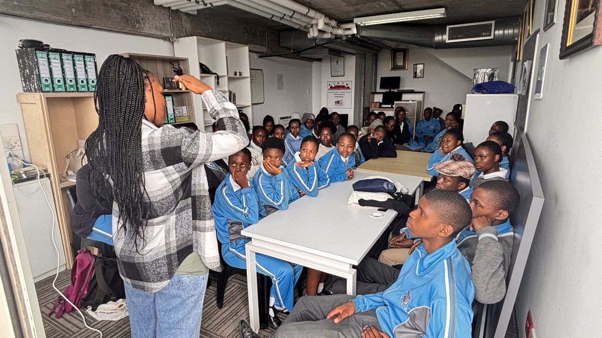 A teacher at the front of a class of students.