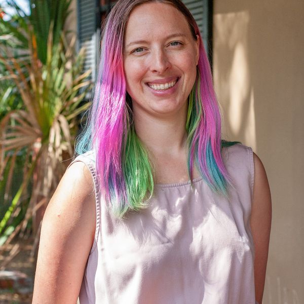 Portrait of Ashley Hermann with pink, green and blue hair