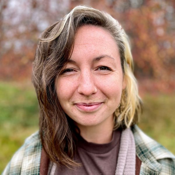 A person smiling for a picture in the outdoors