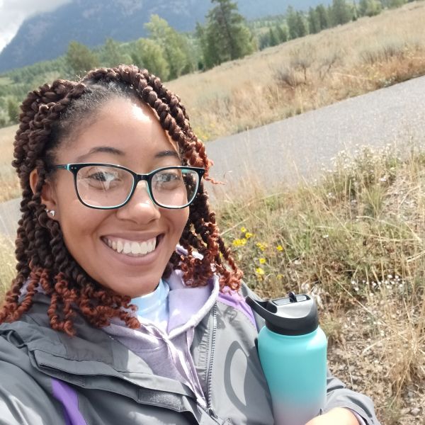 CEE Change Fellow Jaeydah Edwards next to a body of water with trees in the background