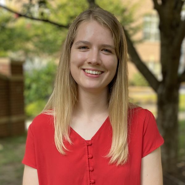 CEE Change Fellow Margaret Beetstra smiling in a red shirt with trees in the background