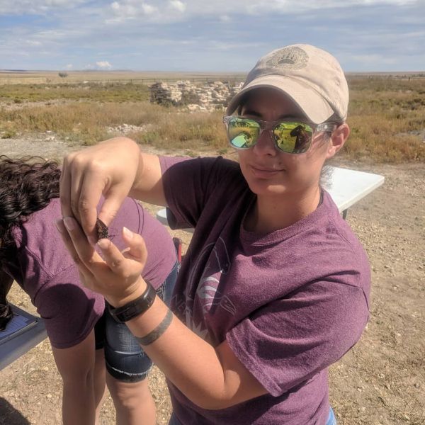 CEE Change Fellow Vanessa Barela holding a small insect in her hands outside