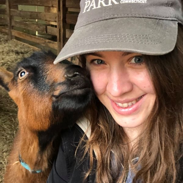 Theresa Nodine wearing a ball cap and next to a horse