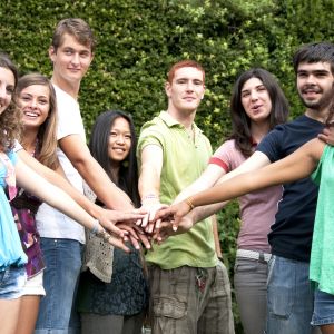 group of college students reaching hands