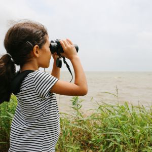 girl looking through binoculars
