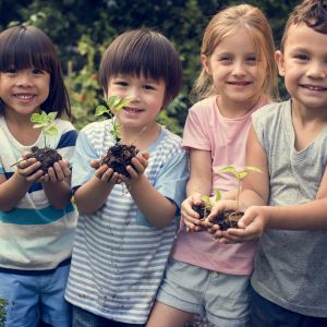 four young children holding seedlings