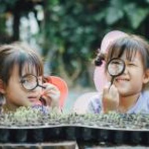 young children looking through magnifying glass