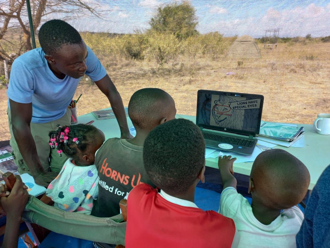 Tobias Odhacha with kids and laptop