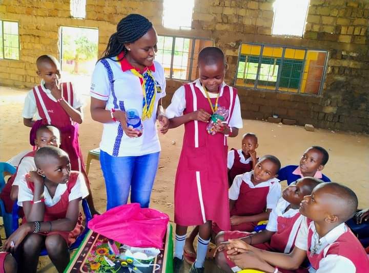 Demonstrating how to make a pencil holder from a plastic bottle. Credit: Eve Gacheri, YESS Girls Movement.