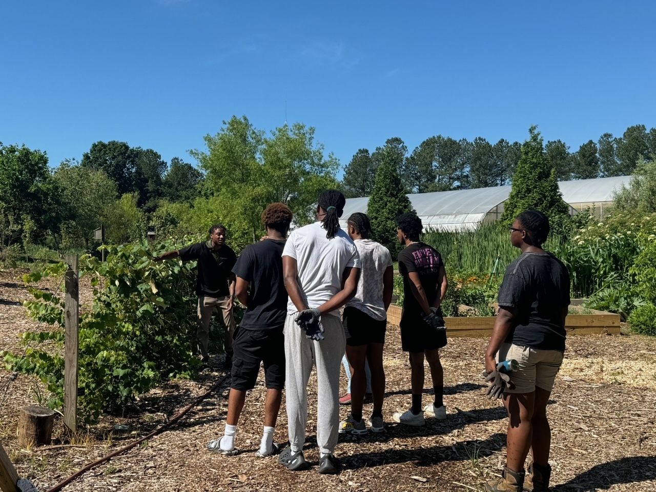  Dajawn Williams leads and educates a group of Kennesaw volunteers through managing the Kennesaw State University Food Forest. Photo Credits go to Lauren Hughes of Kennesaw State University.