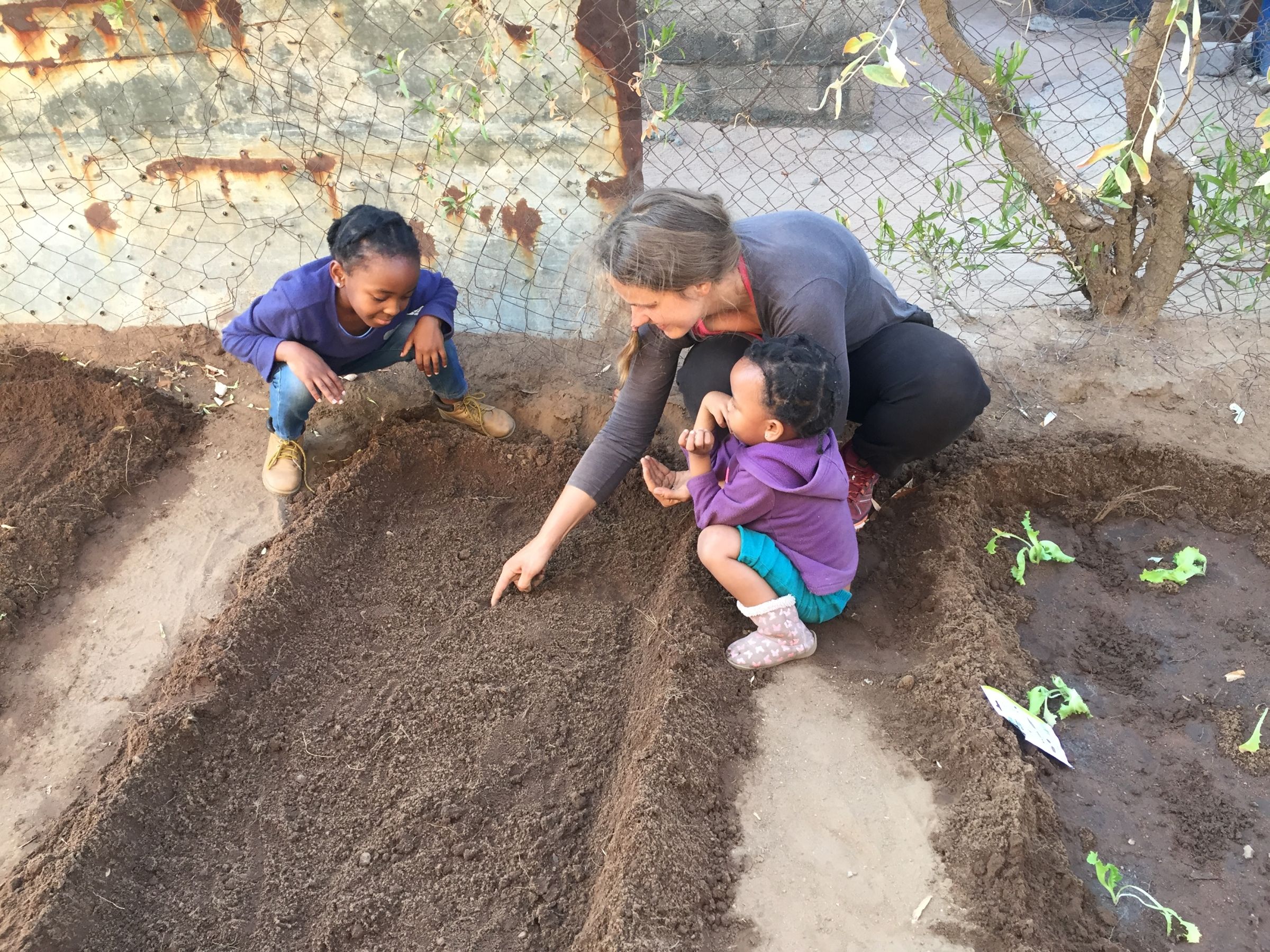 Katka teaching kids how to sow seeds in their very first backyard garden, in rural area of Botswana. 