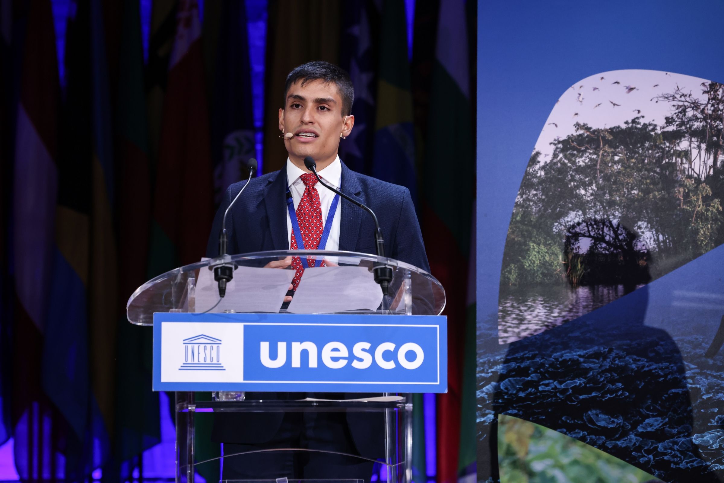 A young man speaking at a UNESCO podium