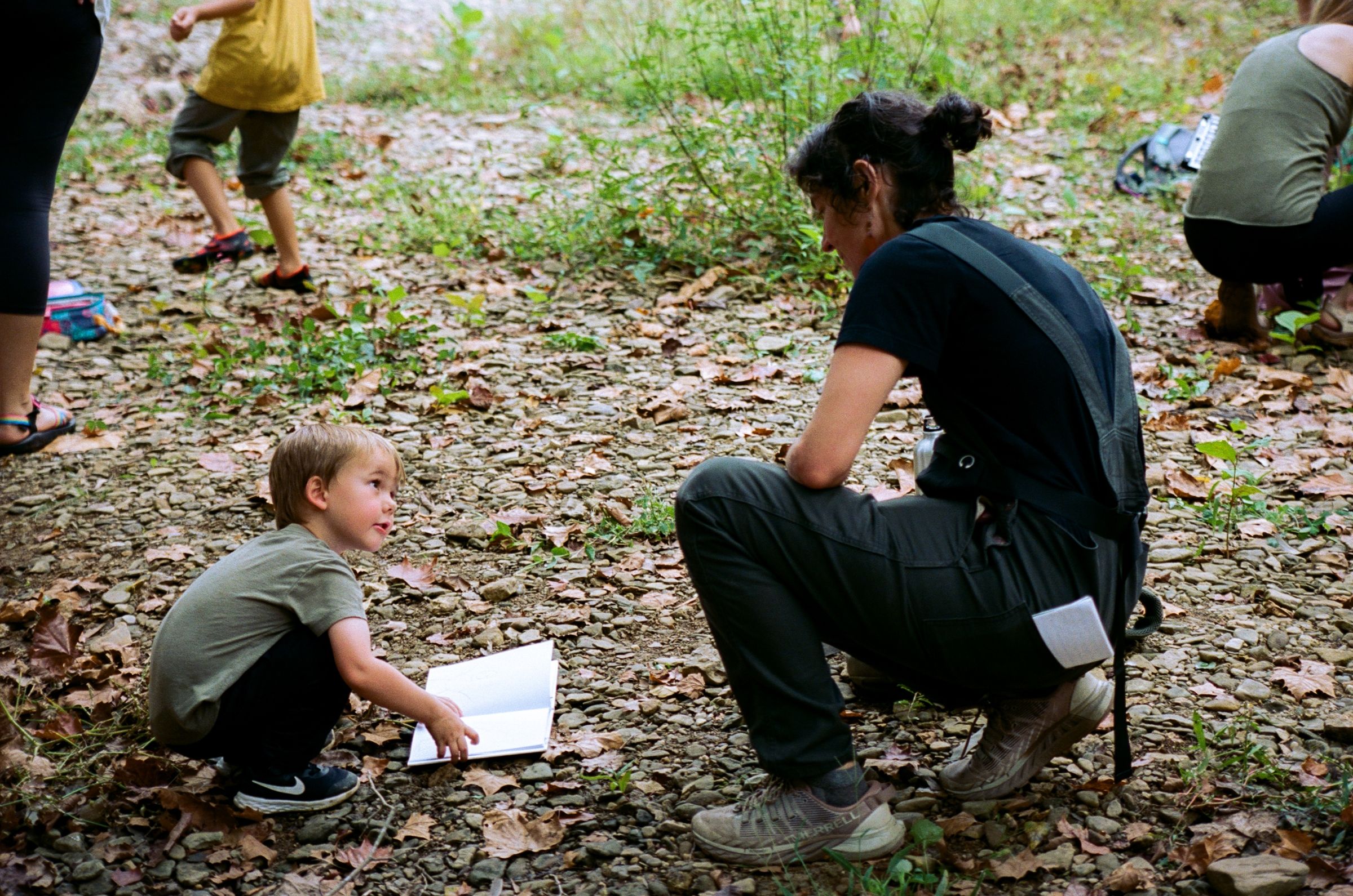 Juliet Grable kneels to interact with a child while filming In Our Nature in Lexington, Kentucky
