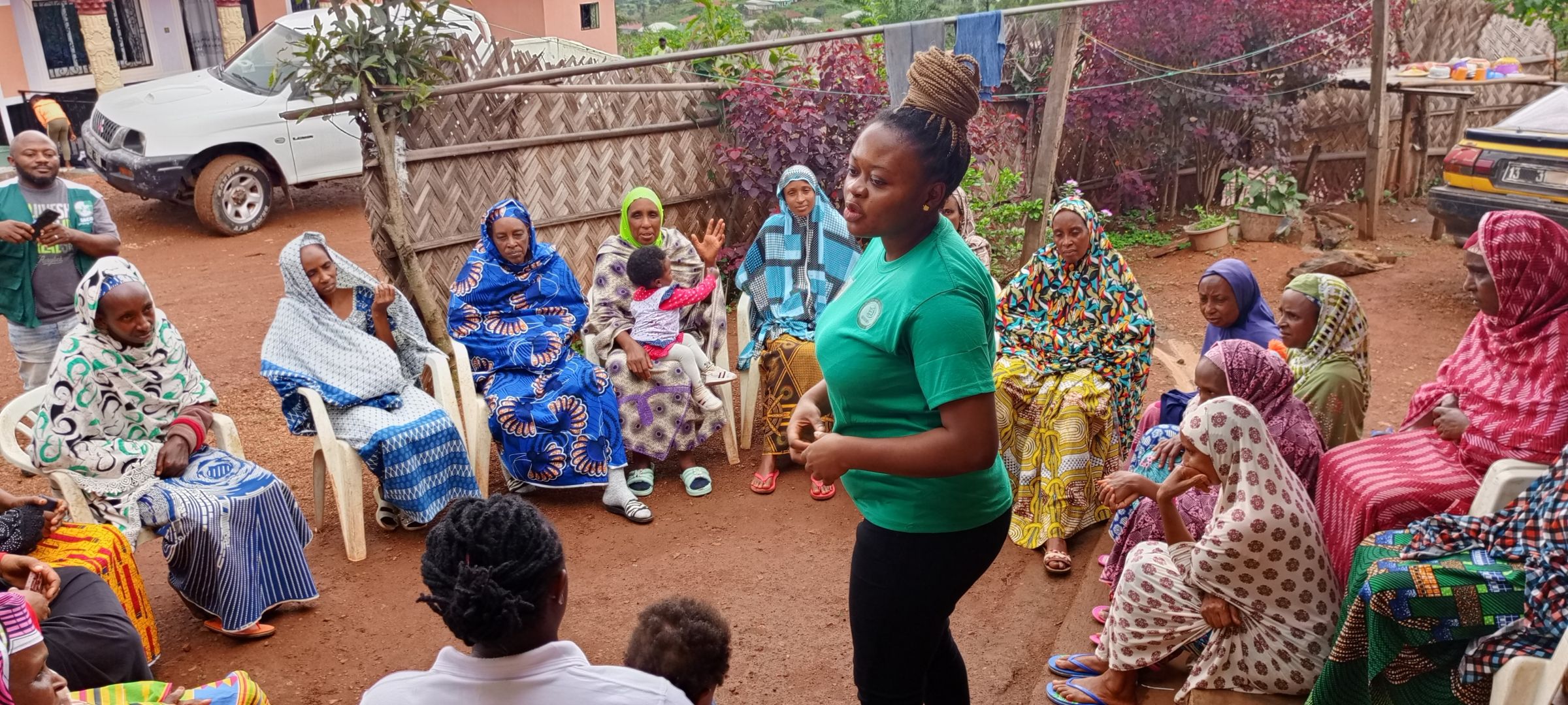 A woman standing in the middle of a circle of community members.