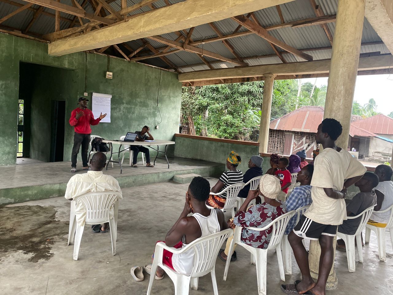 A person teaching at the front of a classroom.