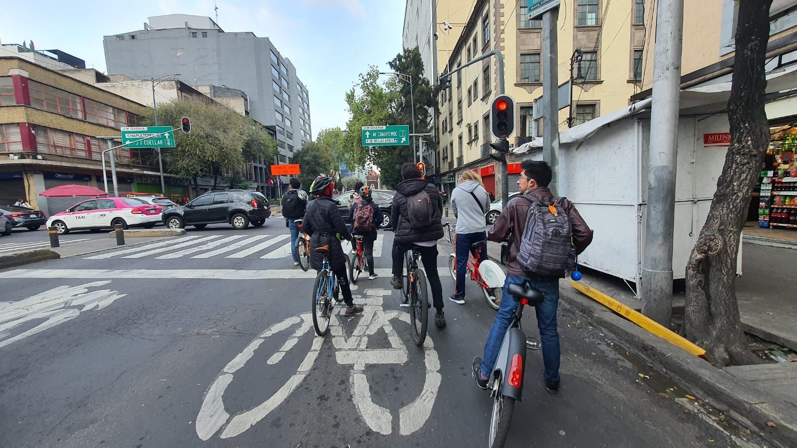 Bikers at a stoplight in the bike lane of an urban city.