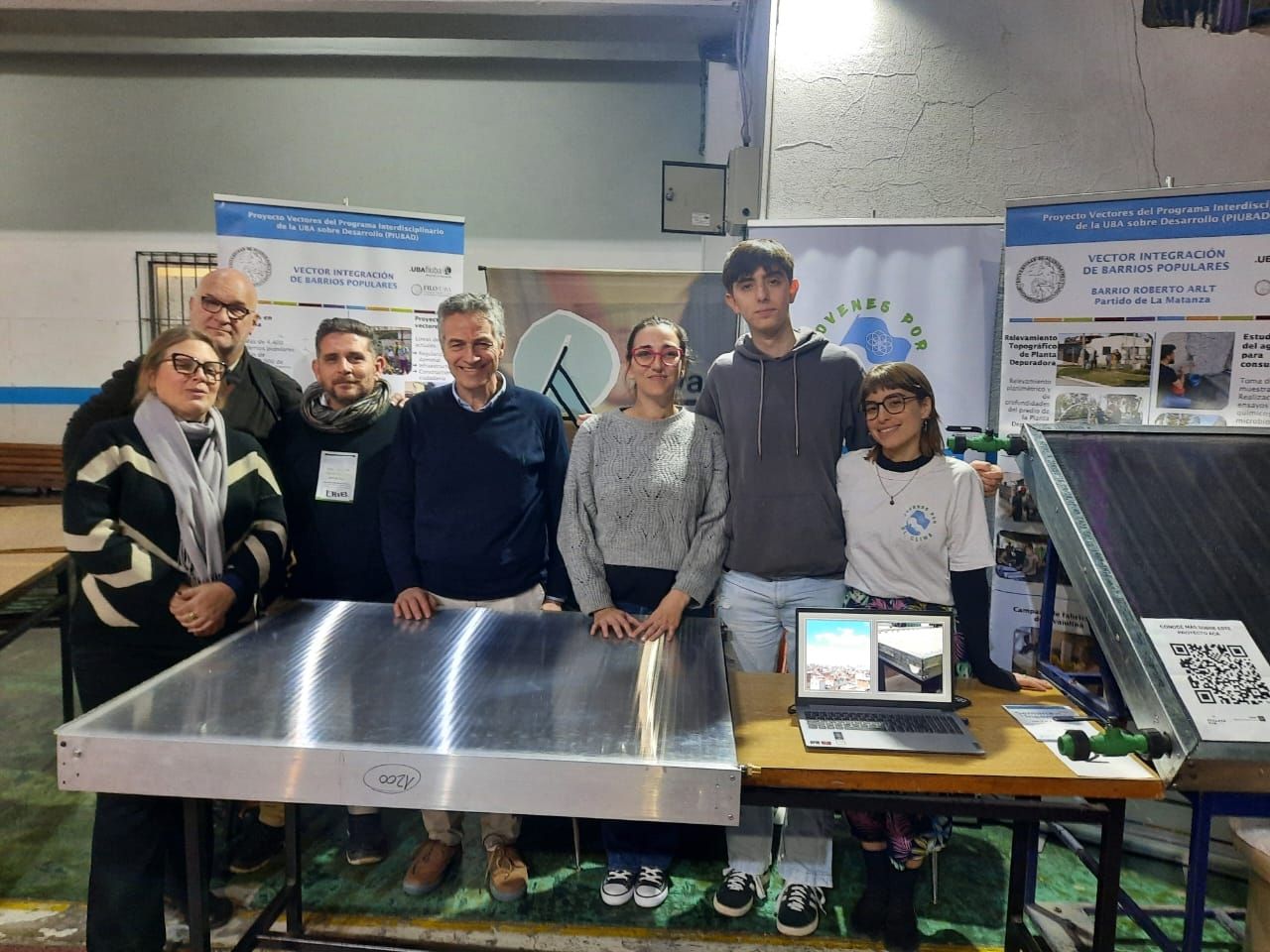 A group of people posing in front of sustainable building materials.