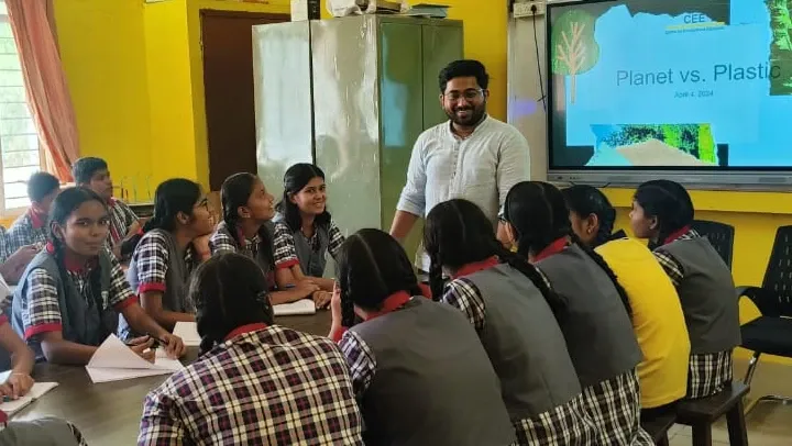 A teacher smiling with a group of students.