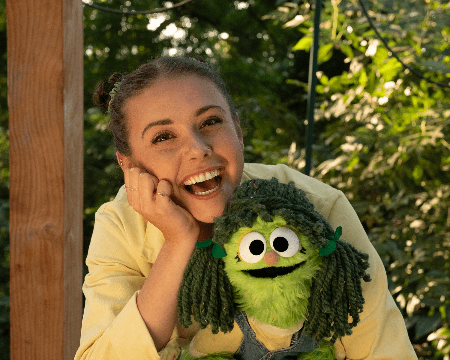 A person smiling with their puppet.
